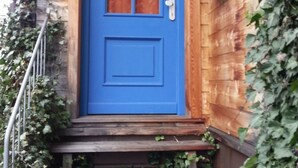 A blue door with a window, wooden steps, and a metal railing. - Studio Blockhaus by Interhome (Bernau)