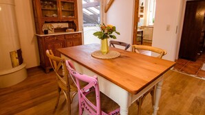 Un comedor con una mesa de madera, sillas y un armario.