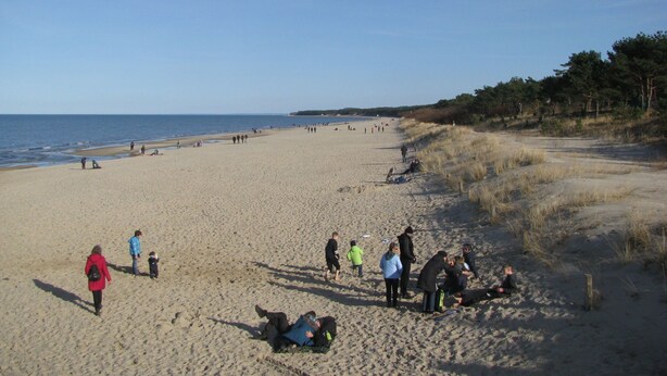 A wide sandy beach with people walking and sitting. - Moderne Ferienwohnung mitten in Greifswald by Interhome (Greifswald)