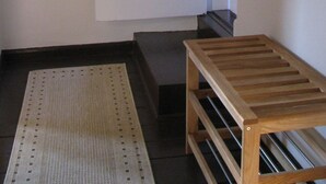A room with a white door, a wooden bench, and a patterned rug. - Moderne Ferienwohnung mitten in Greifswald by Interhome (Greifswald)