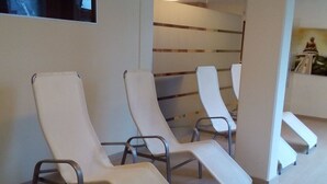 Un'area d'attesa con poltrone reclinabili e pavimento piastrellato.