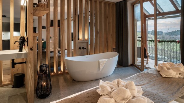 A modern bathroom with a freestanding bathtub, wooden paneling, and a large window offering a view of the outdoors. - EXKLUSIVE FERIENWOHNUNG MIT EIGENER SAUNA by Interhome (Regen)