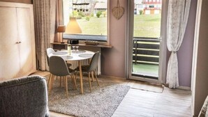 A cozy room with a dining table, chairs, a lamp, and a view of the outdoors through a window. - Harzgeiss by Interhome (Braunlage)