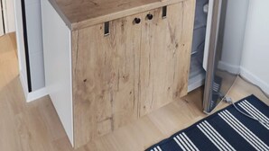 Een compacte kitchenette met een koffiezetapparaat, waterkoker en magnetron op een houten aanrecht.