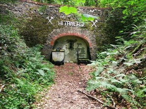 A stone archway leading into a tunnel with a sign reading "HILTLAND" and two crossed swords. - Vacation home 30 by Interhome (Frielendorf)