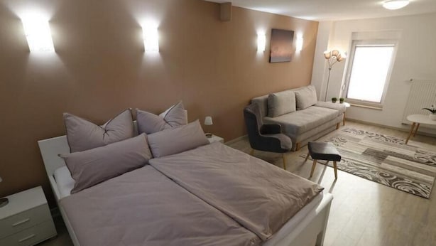 A bedroom with a bed, a sofa, and a small table. - Urlaub und zu Hause by Interhome (Naundorf)