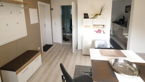 A modern kitchen with white cabinets, a wooden countertop, and a dining area with a table and chairs. - Urlaub und zu Hause by Interhome (Naundorf)