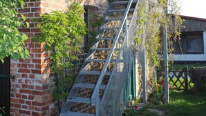 A brick building with a metal staircase leading up to a window. - "Galerie" by Interhome (Kröslin)