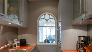 A compact kitchen with a large window, stainless steel appliances, and wooden countertops. - Sönshörn - S20 - in Munkmarsch by Interhome (Archsum)
