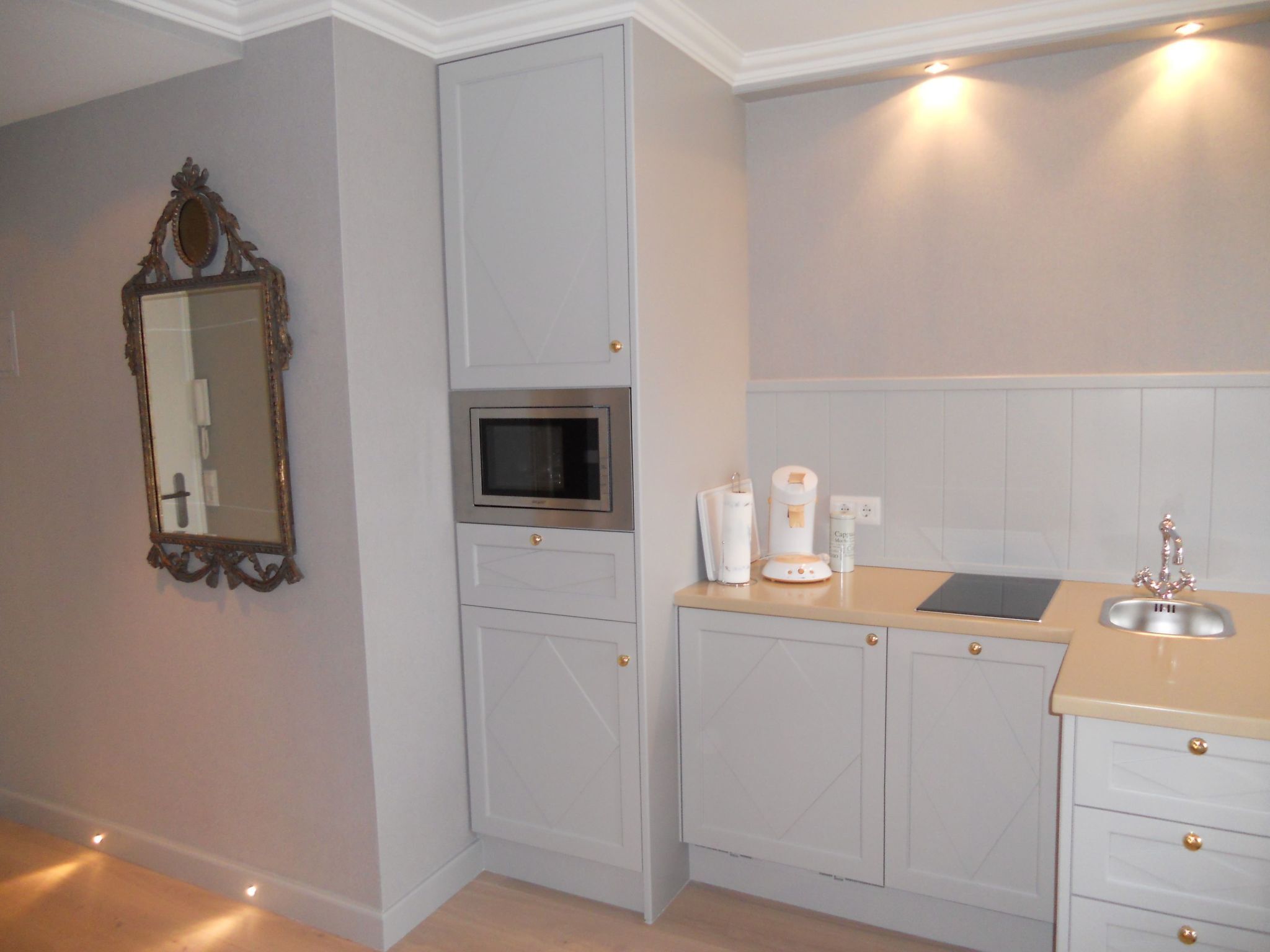 A kitchen with a microwave, a sink, and cabinets.