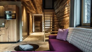 Een modern interieur met een houten plafond, een paarse bank en een keukenhoek.