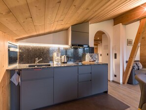 Eine moderne Küche mit einer Granitabdeckung, dunklen Schränken und einem eingebauten Backofen.