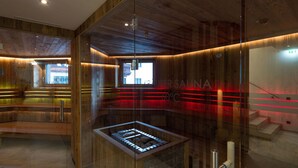 Eine Sauna mit Holzwänden und einer Glaseinfassung, mit sichtbarer Liege und Bedienfeld.