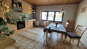 Eine Küche mit Holzausstattung, einem Herd und einem Essbereich mit Tisch und Stühlen.