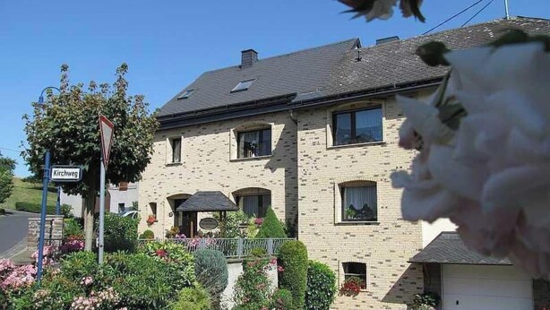 A two-story building with a brick facade, multiple windows, and a visible entrance with a small porch. - Ruhiges Landhaus mit zwei gemütlichen Wohnungen by Interhome (Bereborn)