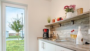 Una cocina moderna con encimera de madera, una cafetera y dos copas de champán.