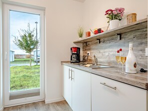 A modern kitchen with a wooden countertop, a coffee maker, and two glasses of champagne. - Schleivilla Lootsen Hus by Seeblick Ferien ORO by Interhome (Hasselberg)