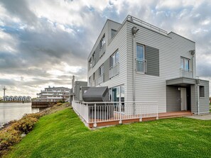 A modern multi-story residential building with a flat roof, large windows, and a balcony. - Schleivilla Lootsen Hus by Seeblick Ferien ORO by Interhome (Hasselberg)