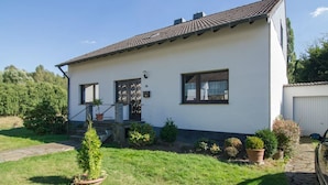 A single-story house with a tiled roof, a front door, and a small porch. - Gemütliches Ferienhaus in Hasenfeld mit Großem Garten by Interhome (Hasenfeld)