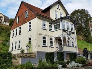 A two-story building with a steeply pitched roof, multiple windows, and a balcony with ornate railings. - Magistartswohnung AltesRathaus by Interhome (Wildemann)