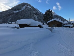 A snow-covered mountain with a wooden cabin and a house in the foreground. - Barbara by Interhome (Bichlbach)