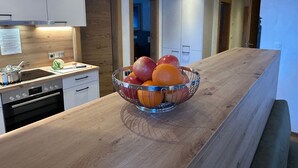 A modern kitchen with a wooden countertop, stainless steel appliances, and a fruit bowl. - Barbara by Interhome (Bichlbach)