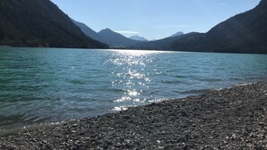 A lake with a rocky shoreline and mountains in the background. - Barbara by Interhome (Bichlbach)