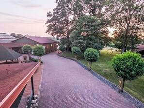 A paved pathway leading to a building with a red roof, surrounded by well-maintained greenery and trees. - Apartment Abendsonne mit eigener Terrasse by Interhome (Klein Meckelsen)