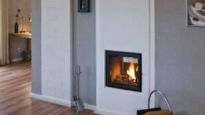 A living room with a fireplace, wooden flooring, and a bookshelf. - Apartment Abendsonne mit eigener Terrasse by Interhome (Klein Meckelsen)