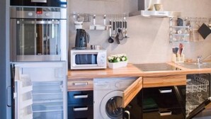 A modern kitchen with stainless steel appliances, a microwave, a coffee maker, and a hanging utensil rack. - Apartment Abendsonne mit eigener Terrasse by Interhome (Klein Meckelsen)