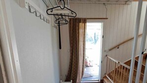 Ein schmaler Flur mit Holzboden, einem Heizkörper und einer weißen Tür.