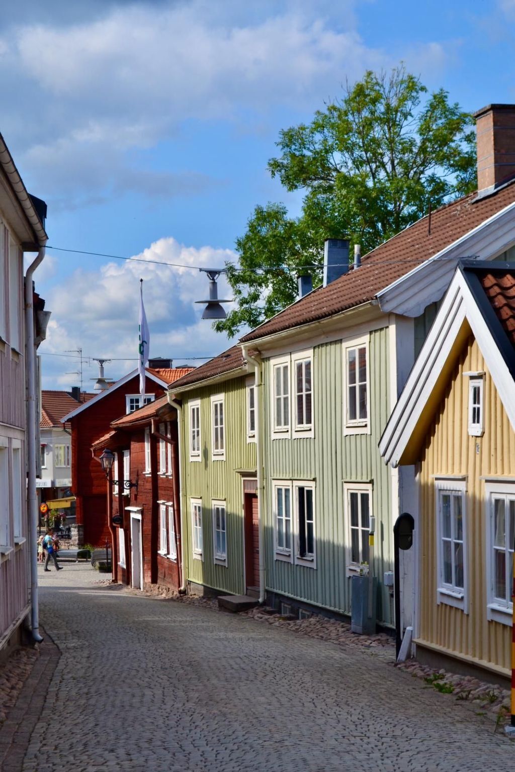 A cobblestone street lined with colorful buildings, featuring a mix of traditional architecture and modern design elements.