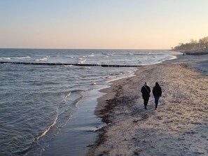 A beach with two people walking along the shore. - U1 ,Silva Mare by Interhome (Kellenhusen)