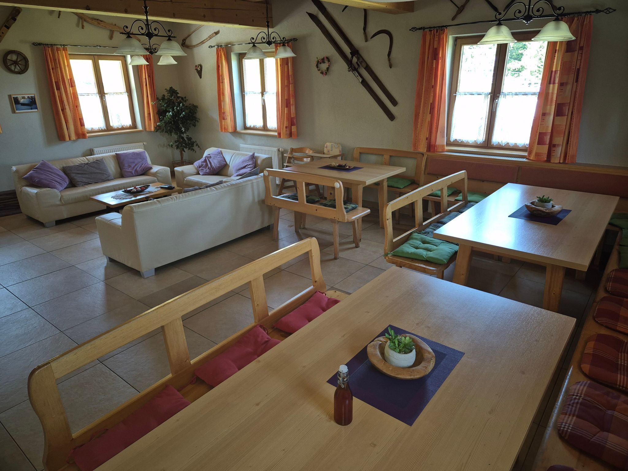 Ein gemütlicher, rustikaler Innenraum mit Holzmöbeln, einer Couch und einem Essbereich.