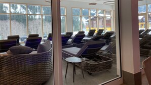 Una stanza spa con poltrone reclinabili, un tavolino e una sedia in vimini.