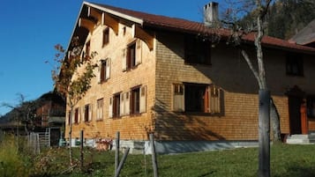 A two-story building with a sloped roof and multiple windows.