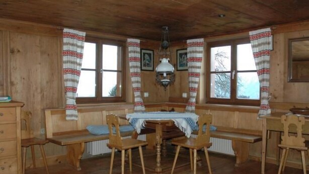 A wooden cabin with a central table, two wooden benches, and a radiator. - Dünser in Dünserberg by Interhome (Dünserberg)
