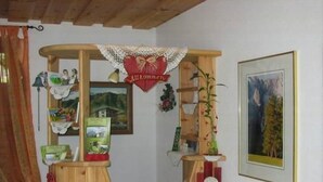 Een houten receptiebalie met een hartvormig bord, ingelijste foto's en een potplant.