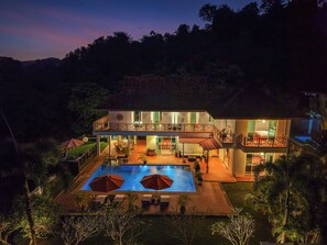 A two-story house with a swimming pool, outdoor seating, and a balcony. - Villa 7 - Luxury Private Pool Villa (Langkawi)