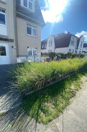 A residential area with houses, a paved path, and a grassy verge. - Helle Ferienwohnung mit sonniger Terrasse by Interhome (Wenningstedt-Braderup)