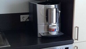Una cocina con cafetera, taza y lavavajillas Siemens.