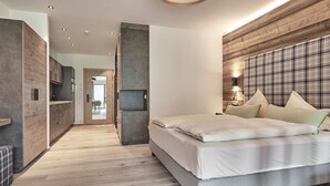 Un dormitorio moderno con una cama grande, paneles de madera y vistas al área de estar contigua.