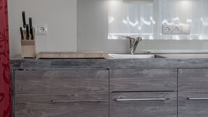 A modern kitchen with a wooden countertop, a sink, and a knife block. - The Peak Sölden by Interhome (Sölden)