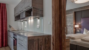 A modern kitchen with wooden cabinetry and a built-in oven. - The Peak Sölden by Interhome (Sölden)