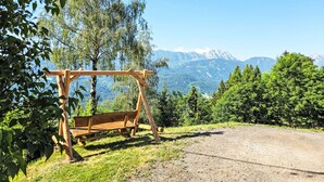 Ein hölzernes Schaukelgerüst in einer natürlichen Umgebung mit freiem Blick auf ferne Berge.