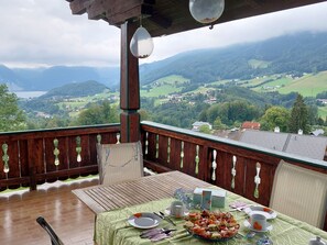 Ein Balkon mit Esstisch, mit Blick auf eine Berglandschaft.