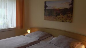 A double bed with a headboard, a bedside lamp, and a window with sheer curtains. - mit überdachter Terrasse und Carport by Interhome (Walsrode)