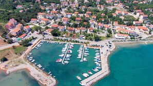 An aerial view of a coastal town with a marina, residential buildings, and a beach area. - Apartment PintaDeSol by Interhome (Krk/Čižići)