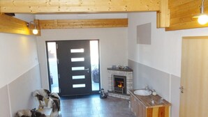 Una stanza con un caminetto, un lavandino e una porta che dà sull'esterno.