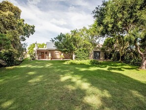 A house with a well-maintained lawn, a patio, and a garage.